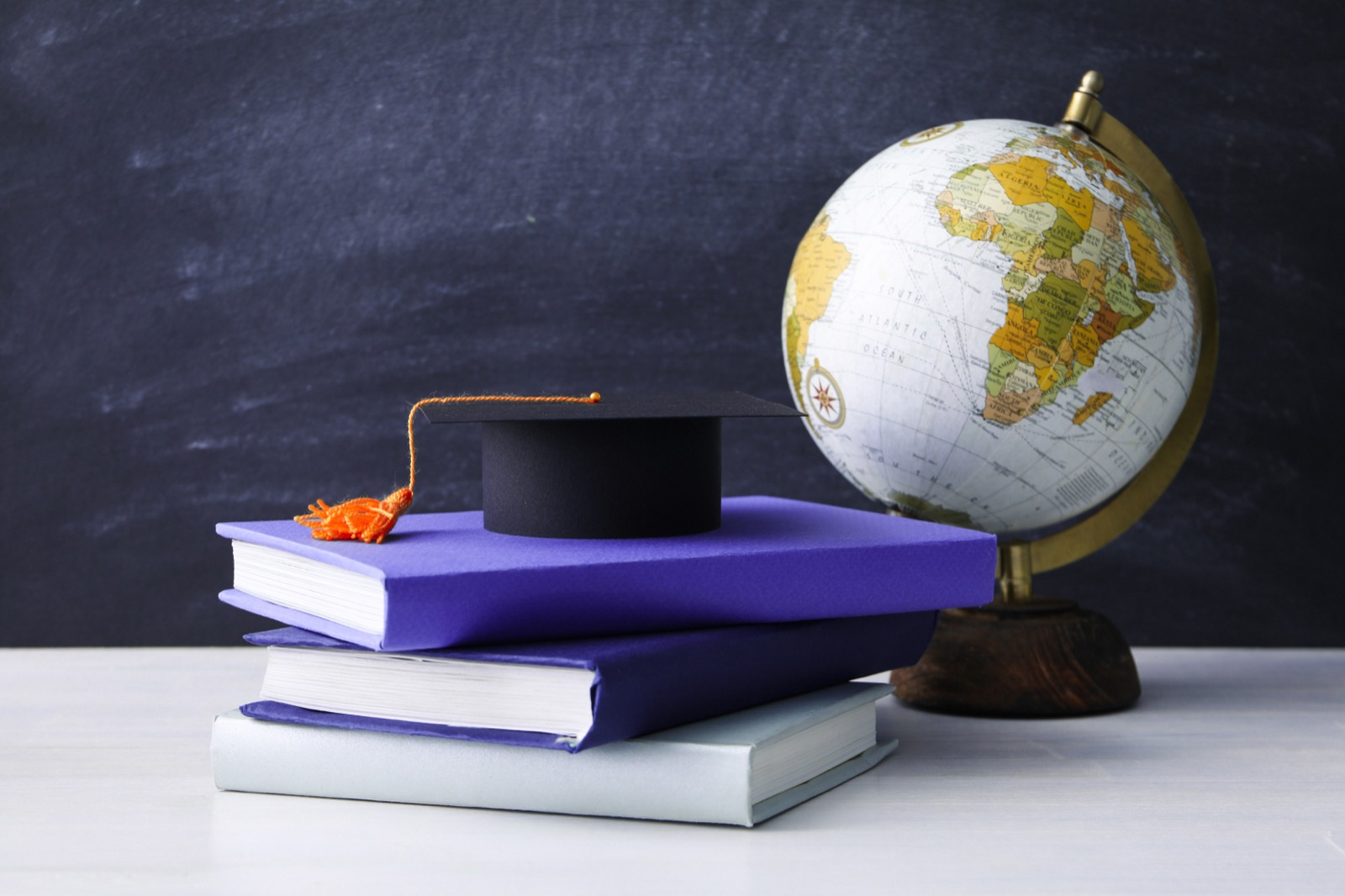 Books, a graduation cap, and a globe